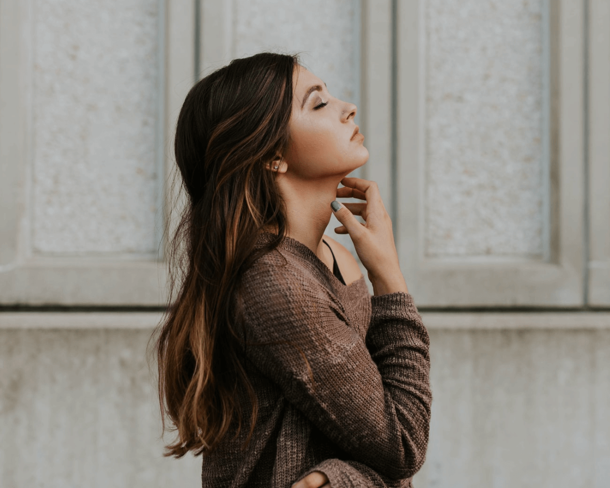 a beautiful woman, one arm around waist, another one holding her face
